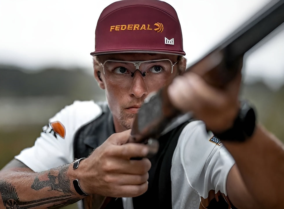 a man holding a gun and wear shooting glasses
